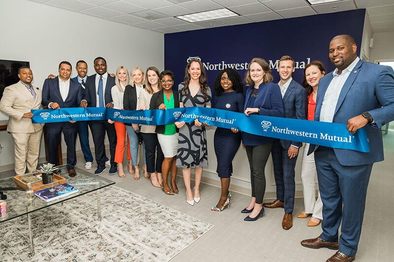The Bowie office team holding their ceremonial grand opening ribbon.