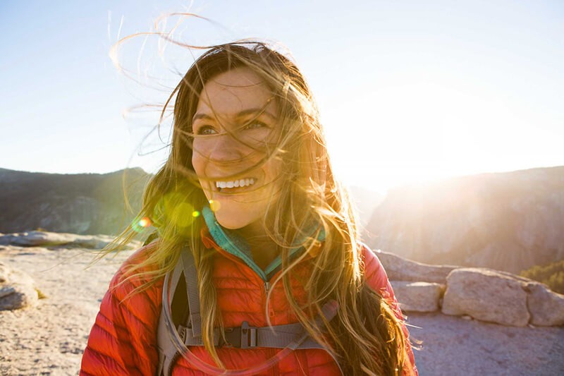 A woman smiling and hiking